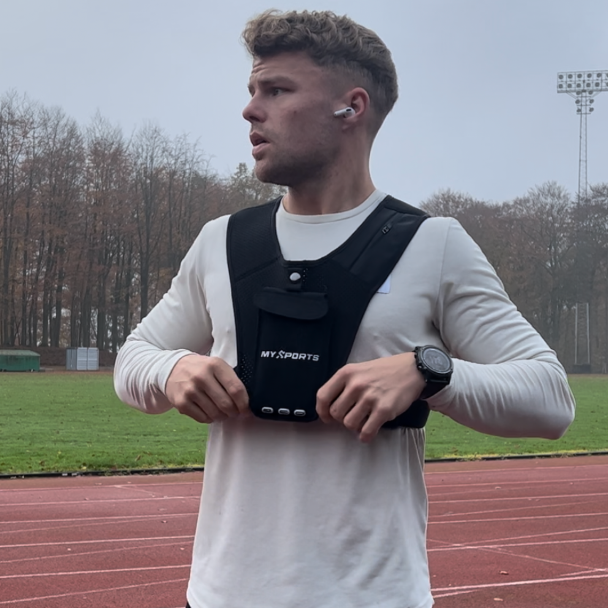 Løber iført MySports løbevest under opvarmning på løbebane i efterårskulisse